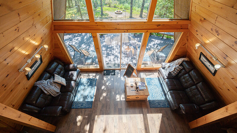 Comfortable living area with a view tempting our guests to get outside and explore the grounds at Peckerwood Knob Cabins in Oklahoma.