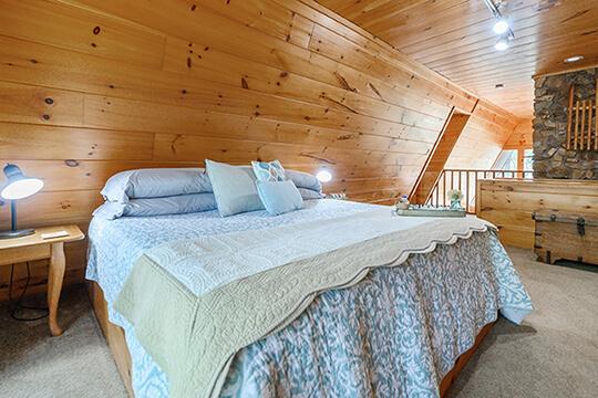 Large king size bed in the master suite at the Sunrise Cabin at Peckerwood Knob Oklahoma Cabin Rentals