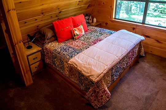 comfortable queen-sized bed at the Sunrise Cabin at Peckerwood Knob Oklahoma Cabin Rentals