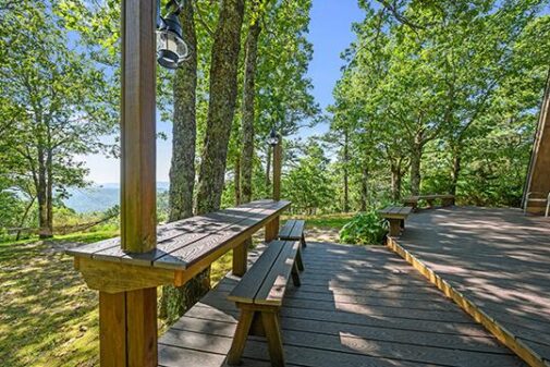 Comfort and beauty surround you as you relax on the large deck at your Sunrise Cabin